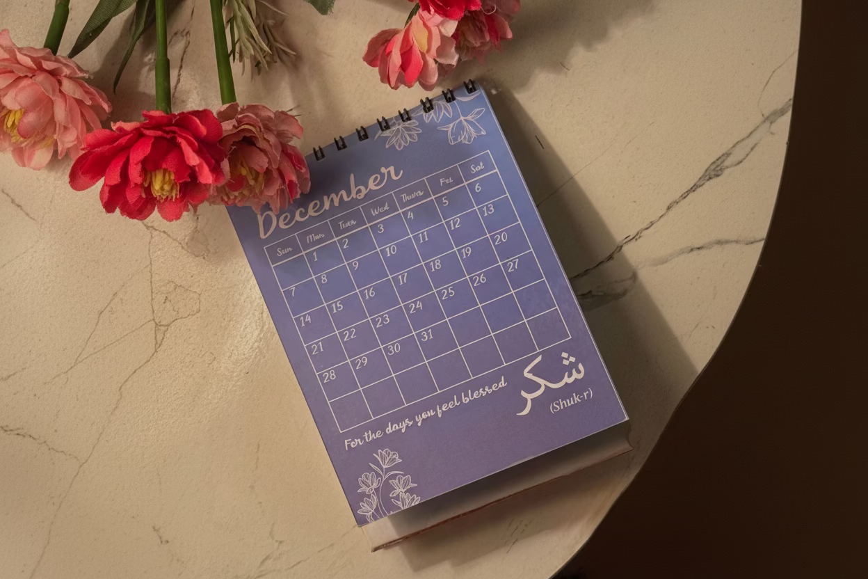 Purple calendar with floral design on a light surface with flowers around