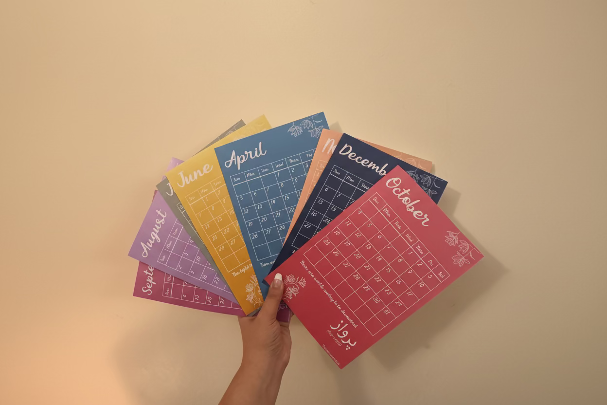 Colorful calendar cards held by a hand against a beige background